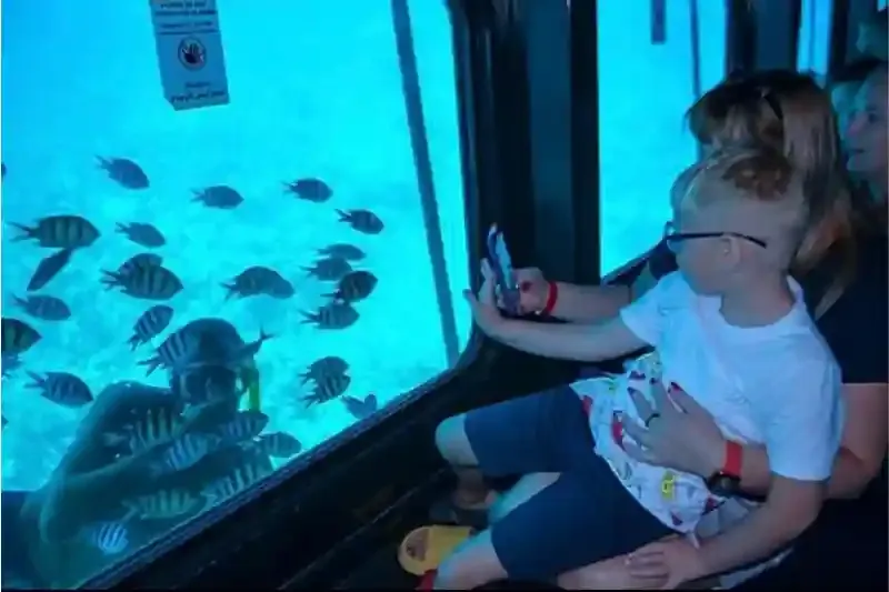 Famiglia sorridente osserva i coralli dal sottomarino Hurghada