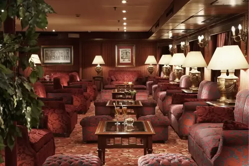 Elegante lounge a bordo della Jaz Crown Jewel, crociera sul Nilo in Egitto. Spazio raffinato con comodi divani, illuminazione accogliente e vista panoramica sul Nilo.